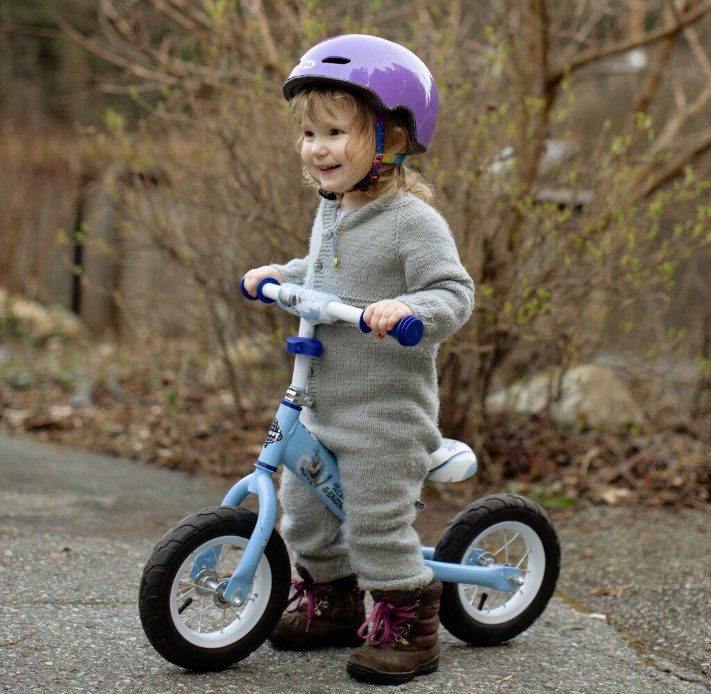 A Child riding a bike for the first time.